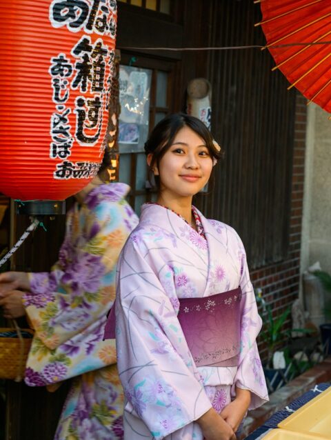 A woman in a kimono standing in front of a store