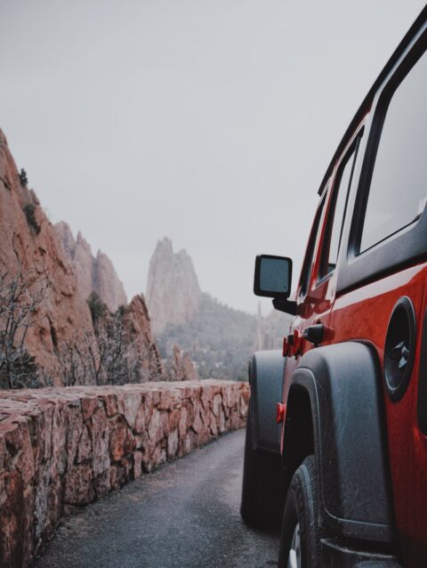 A red jeep parked on the side of a road