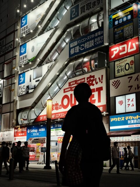 A group of people walking down a street at night