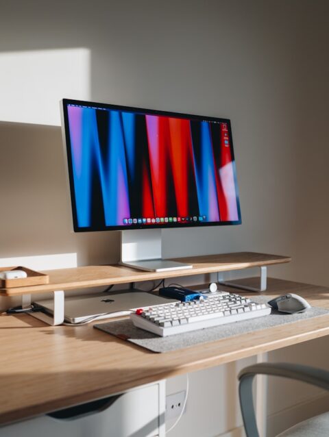 A computer desk with a monitor and keyboard