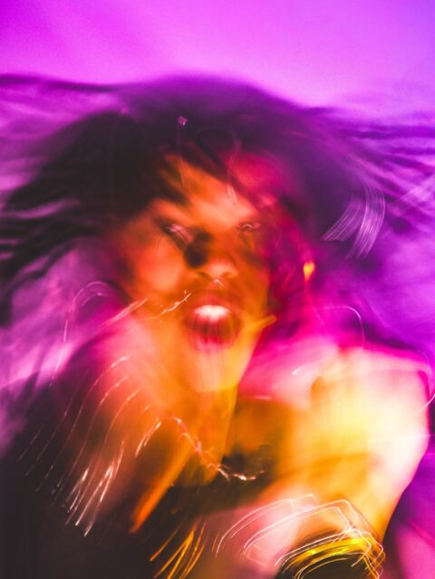 A blurry photo of a woman with her hair blowing in the wind