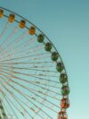 A large ferris wheel sitting next to a tall building