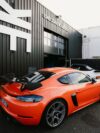 An orange sports car parked in front of a building