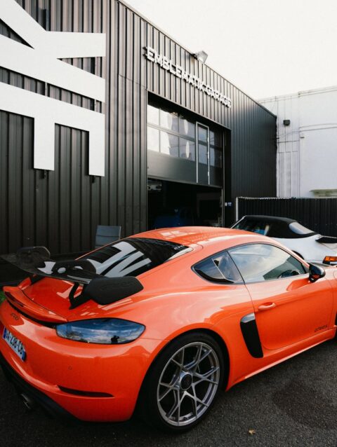 An orange sports car parked in front of a building