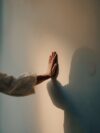 A person reaching out their hand to touch the wall