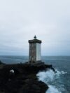 A lighthouse sitting on top of a cliff next to the ocean