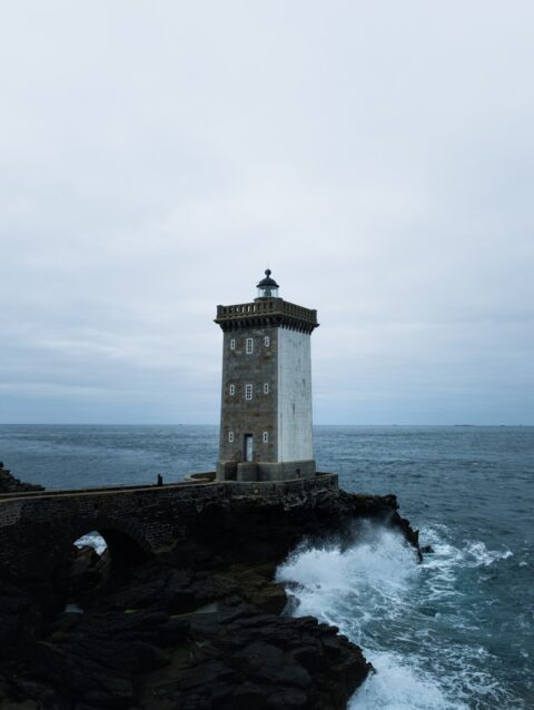 A lighthouse sitting on top of a cliff next to the ocean