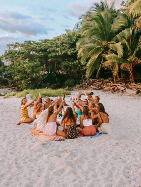 A group of people sitting on top of a sandy beach