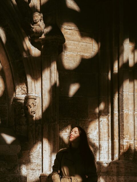 A woman sitting on a bench in front of a building