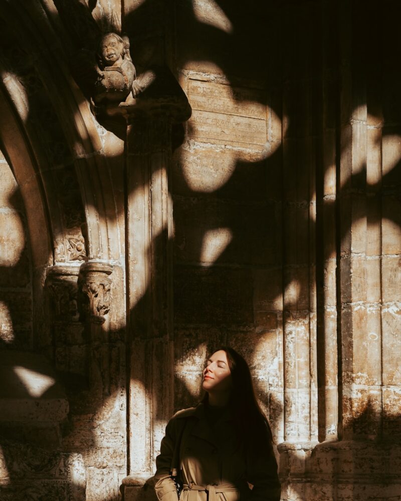 A woman sitting on a bench in front of a building
