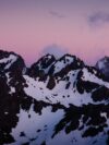 A mountain range with snow covered mountains in the background