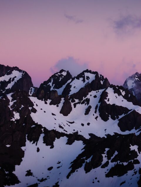 A mountain range with snow covered mountains in the background