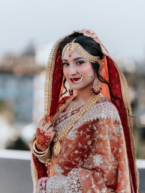 A woman dressed in a bridal outfit posing for a picture