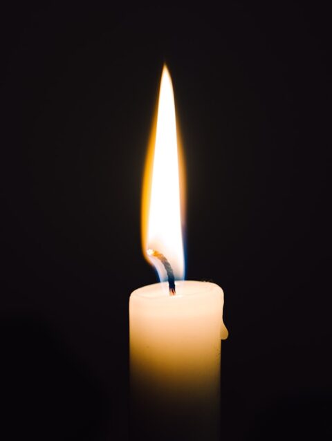 A lit candle with a black background