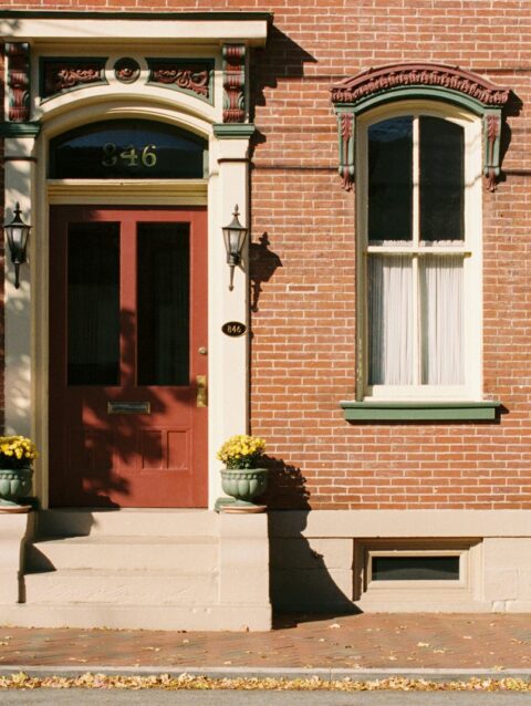 A red fire hydrant sitting in front of a brick building
