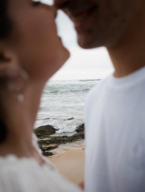 A man and a woman standing next to each other on a beach