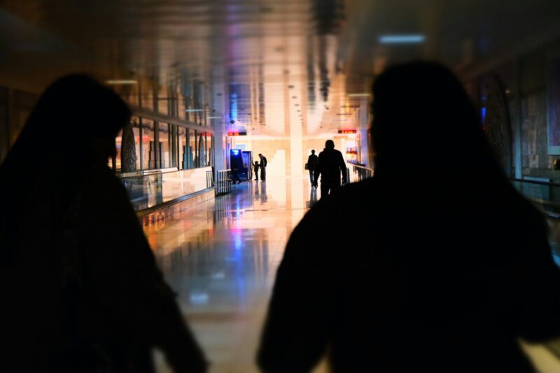 A couple of people walking down a hallway