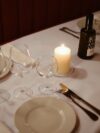 A table set for a formal dinner with a lit candle
