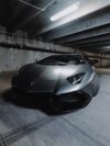 A black sports car parked in a parking garage