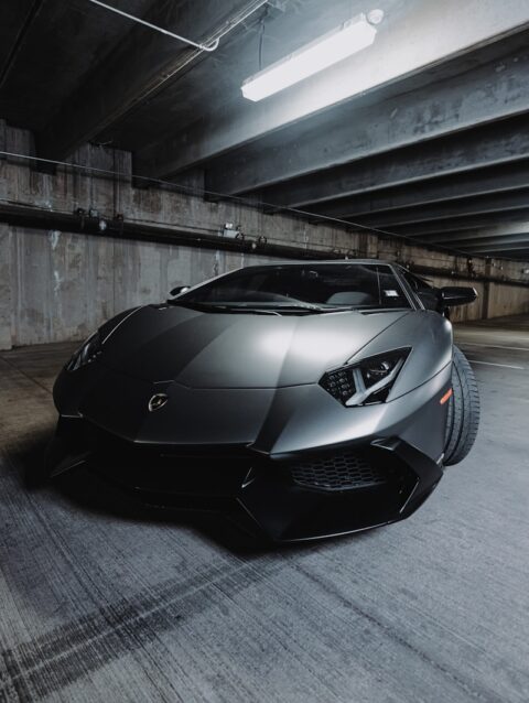 A black sports car parked in a parking garage