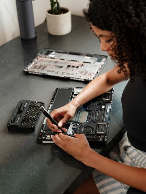 A woman sitting at a table working on a laptop