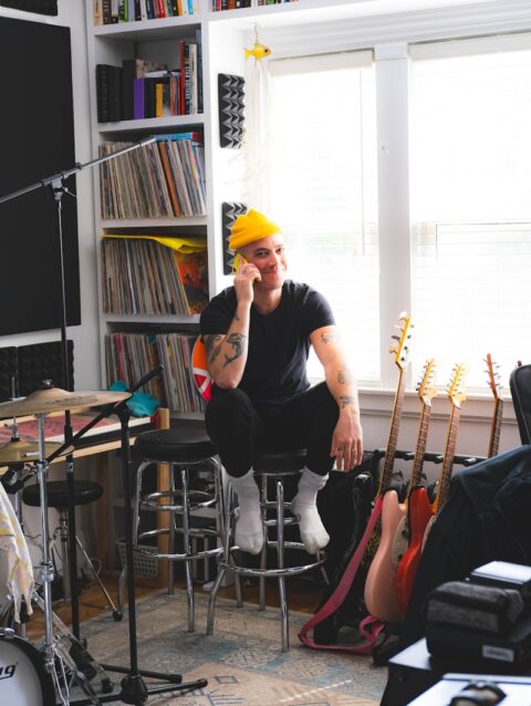 A man sitting in a room with a guitar