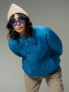 A woman in a blue jacket and hat posing for a picture