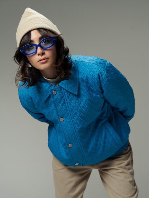 A woman in a blue jacket and hat posing for a picture