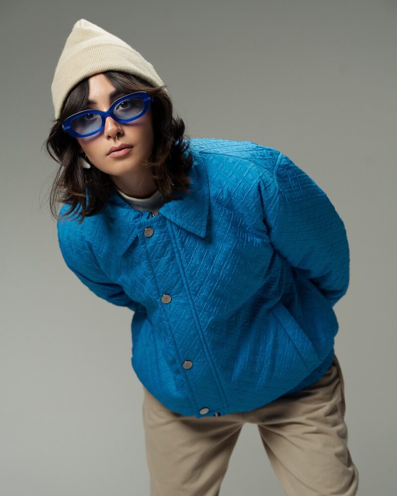A woman in a blue jacket and hat posing for a picture