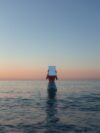 A person standing in the water with a box on their head