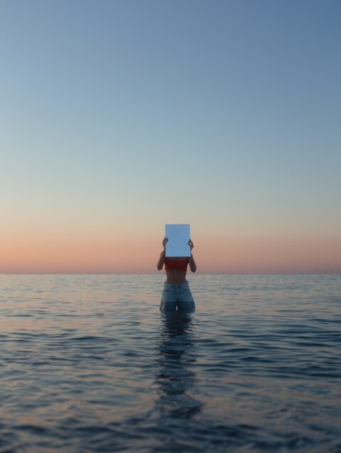 A person standing in the water with a box on their head