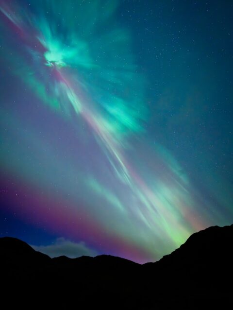 A green and purple aurora bore in the night sky