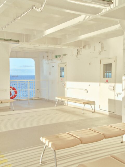 A room with a bench and a view of the ocean