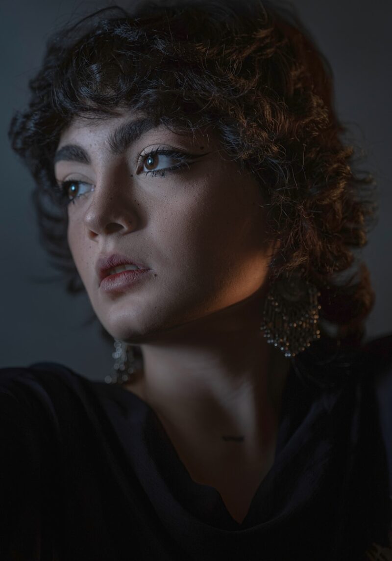 A woman in a dark room with a candle in her hand