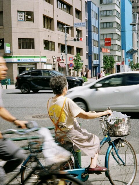 A couple of people riding bikes down a street